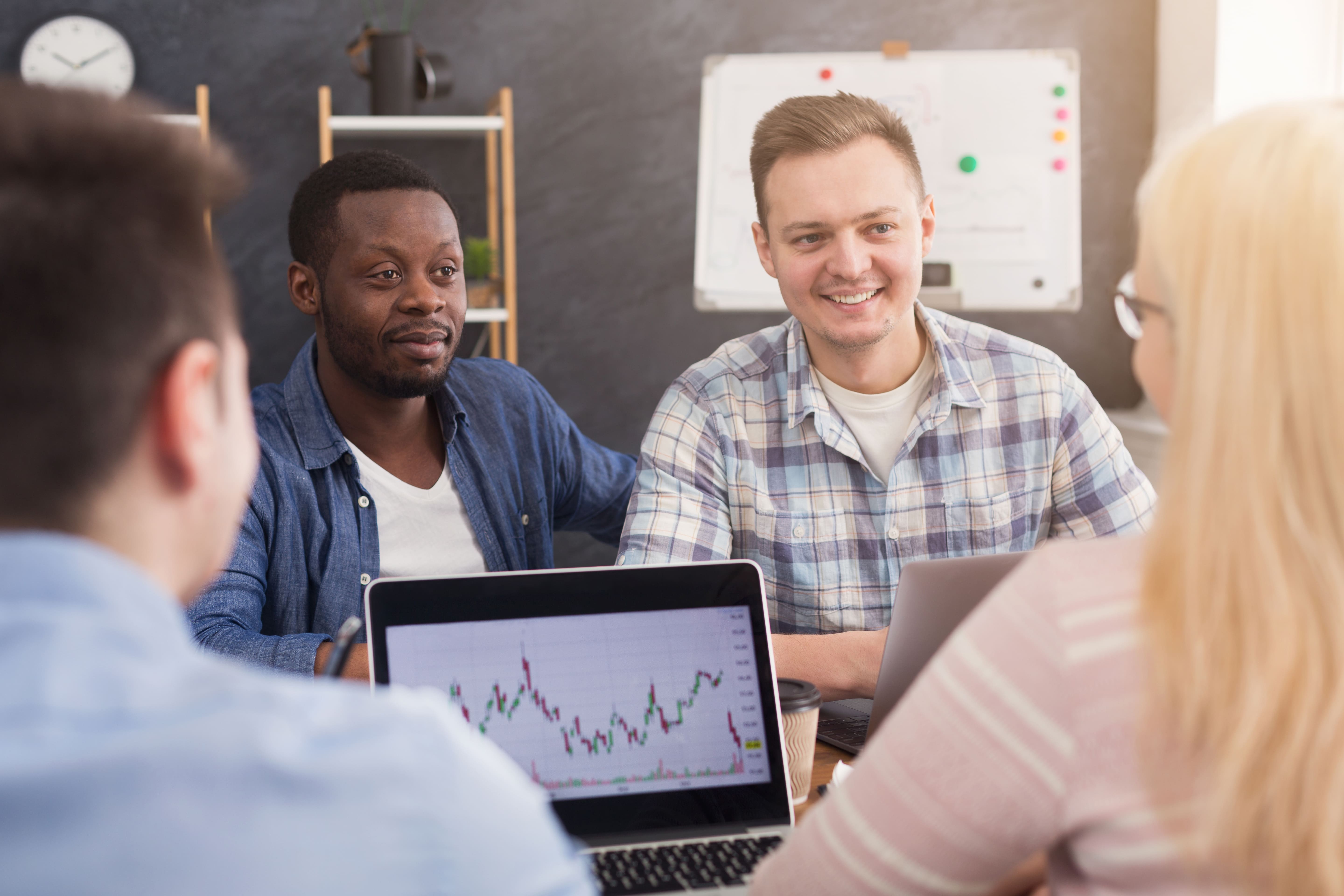 A team talking through a chart on a laptop