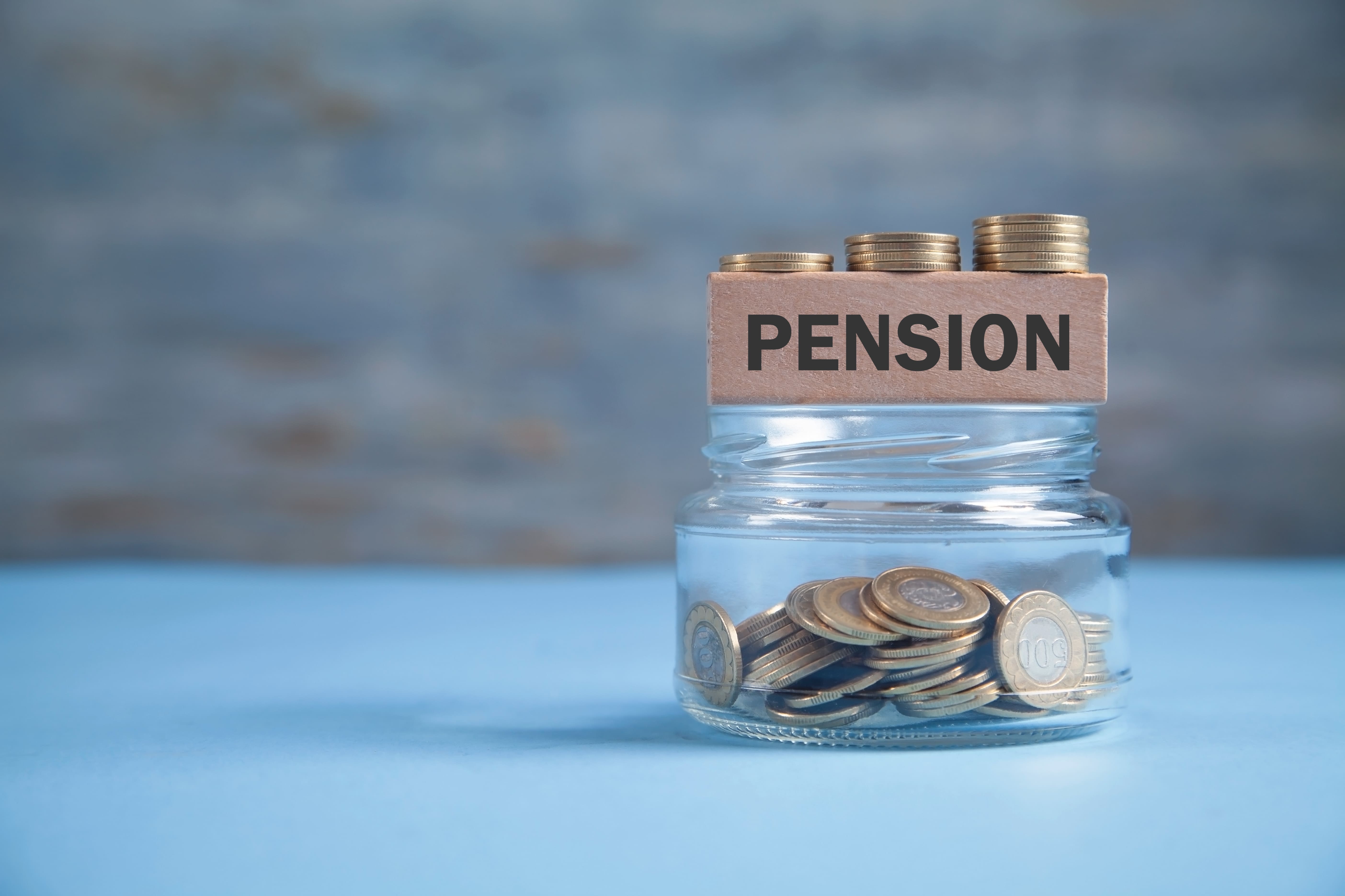Coins in a glass jar, saving for a pension