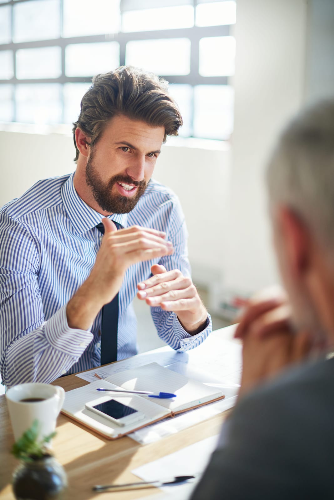 An adviser talking with a client across a meeting table