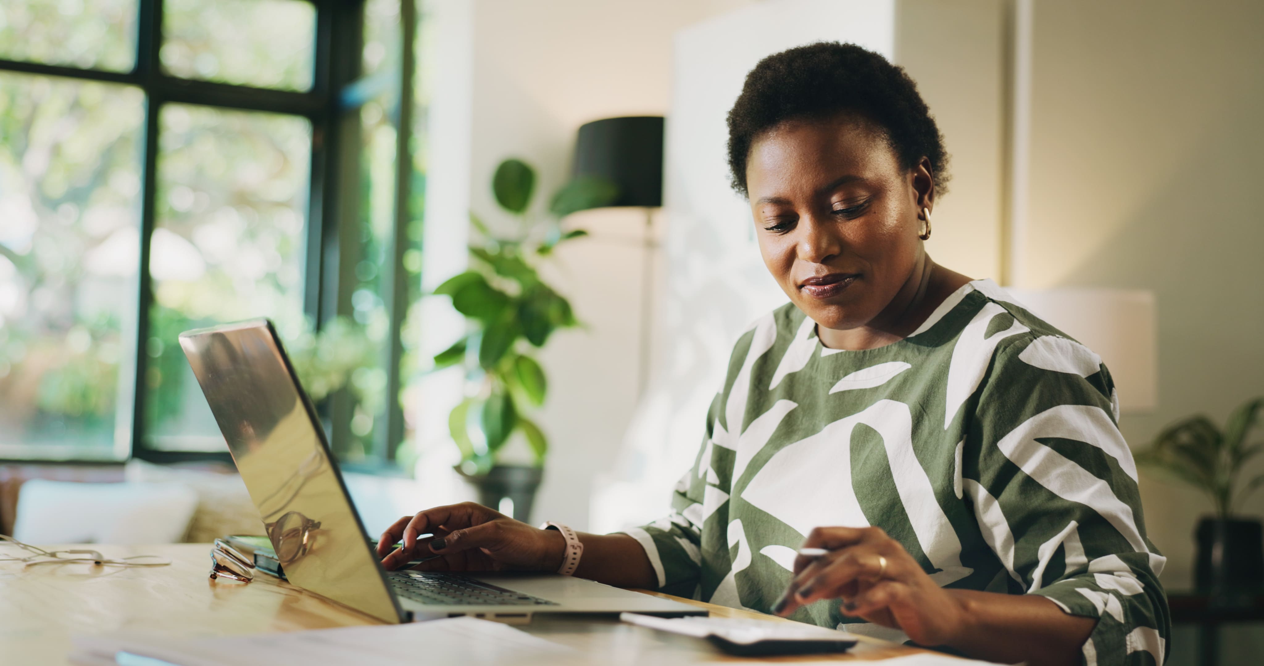 A business owner working at a laptop in a bright office